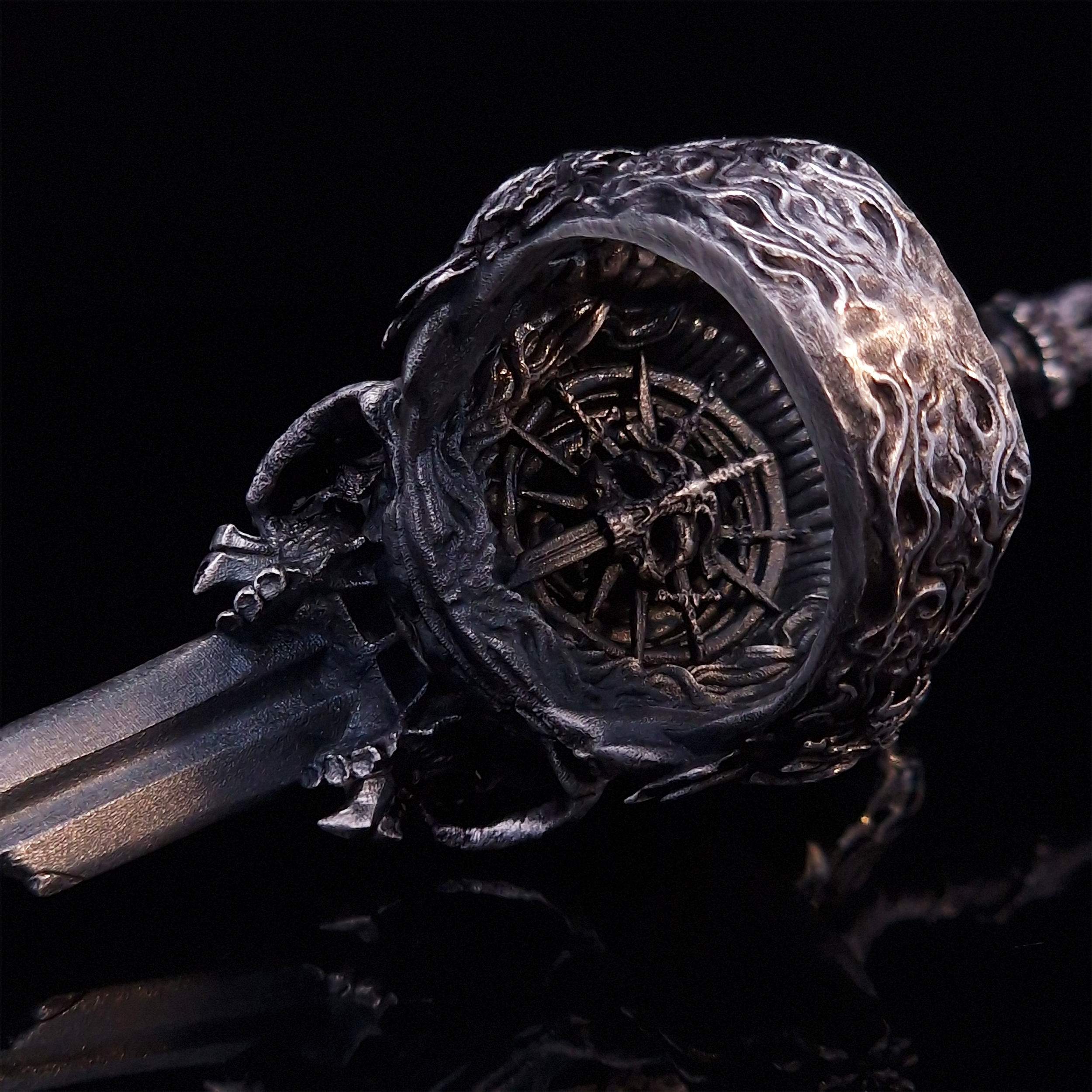 Rear view of the Adversarius Mortis ring in the Fallen finish, focusing on the internal and back design, on a turntable with a black background.