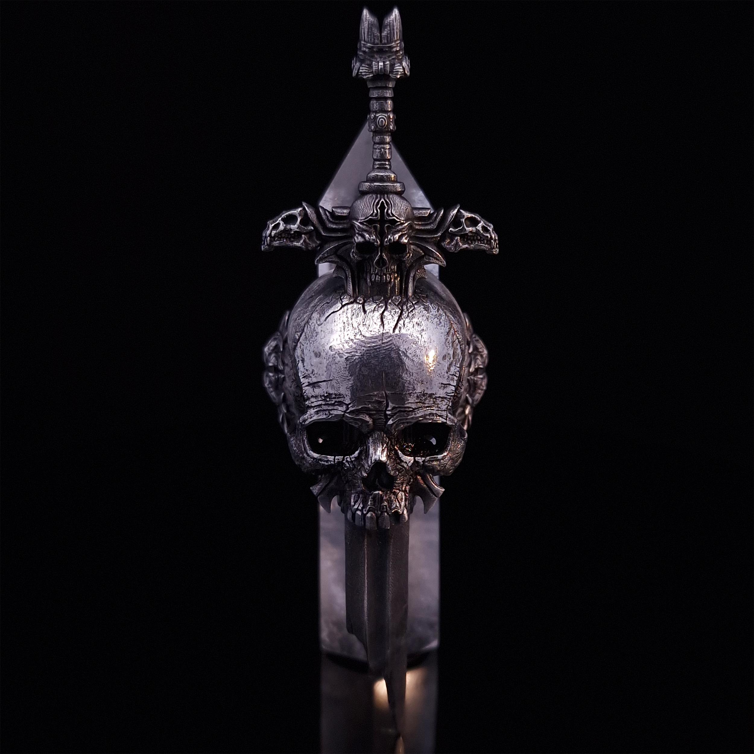Front-facing view of the Adversarius Mortis ring in the Fallen finish, supported by a crystal for balance, shown on a turntable with a black background.