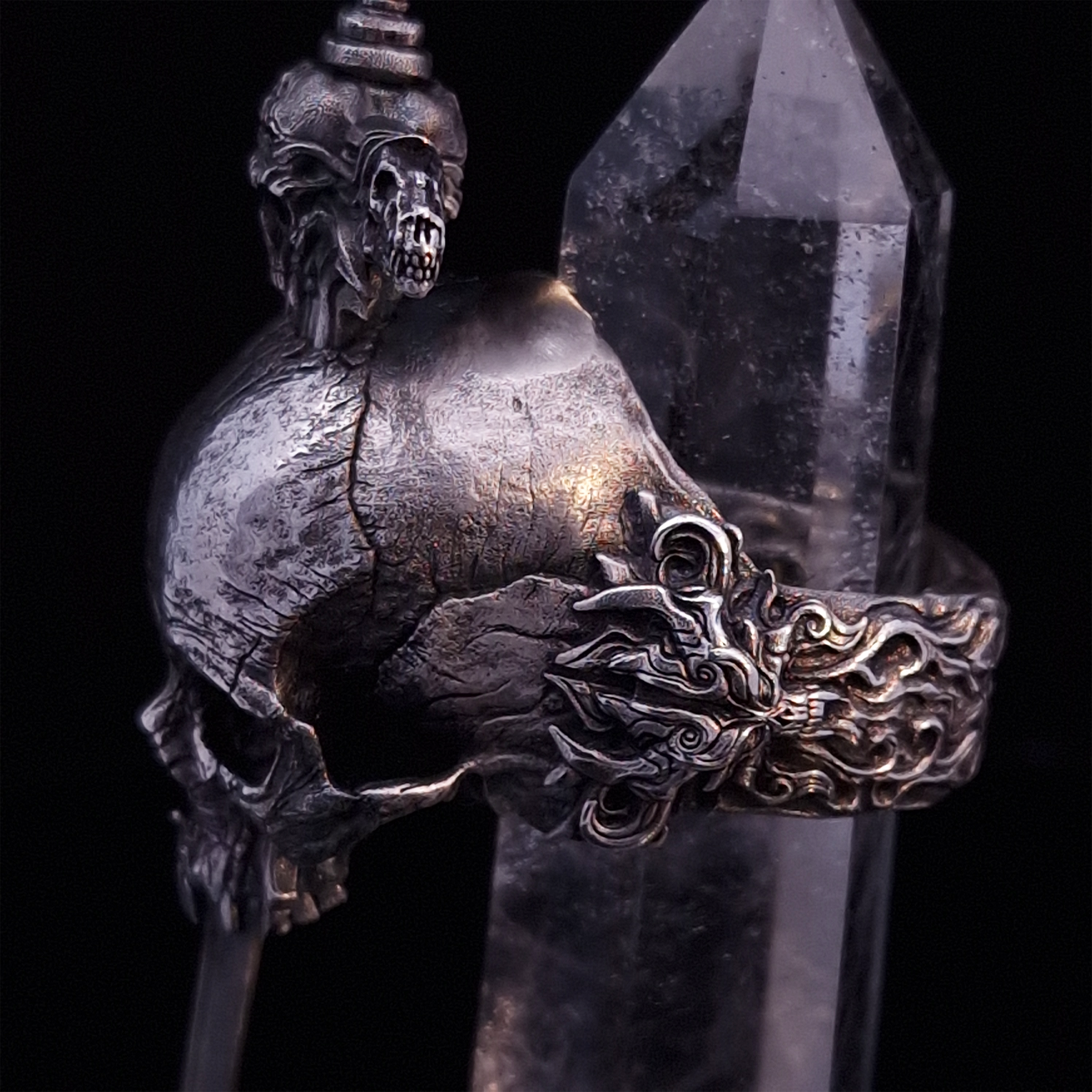Close-up side-left view of the Adversarius Mortis ring in the Fallen finish, with crystal support visible, highlighting the intricate band design on a turntable.