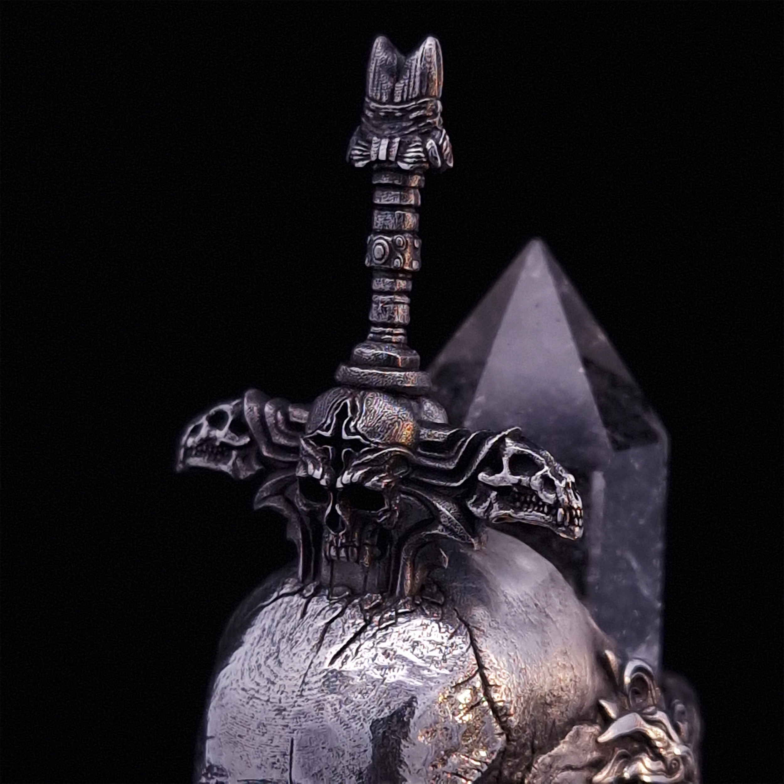 Front-left facing close-up view of the Adversarius Mortis ring in the Fallen finish, focusing on the design of the sword handle.