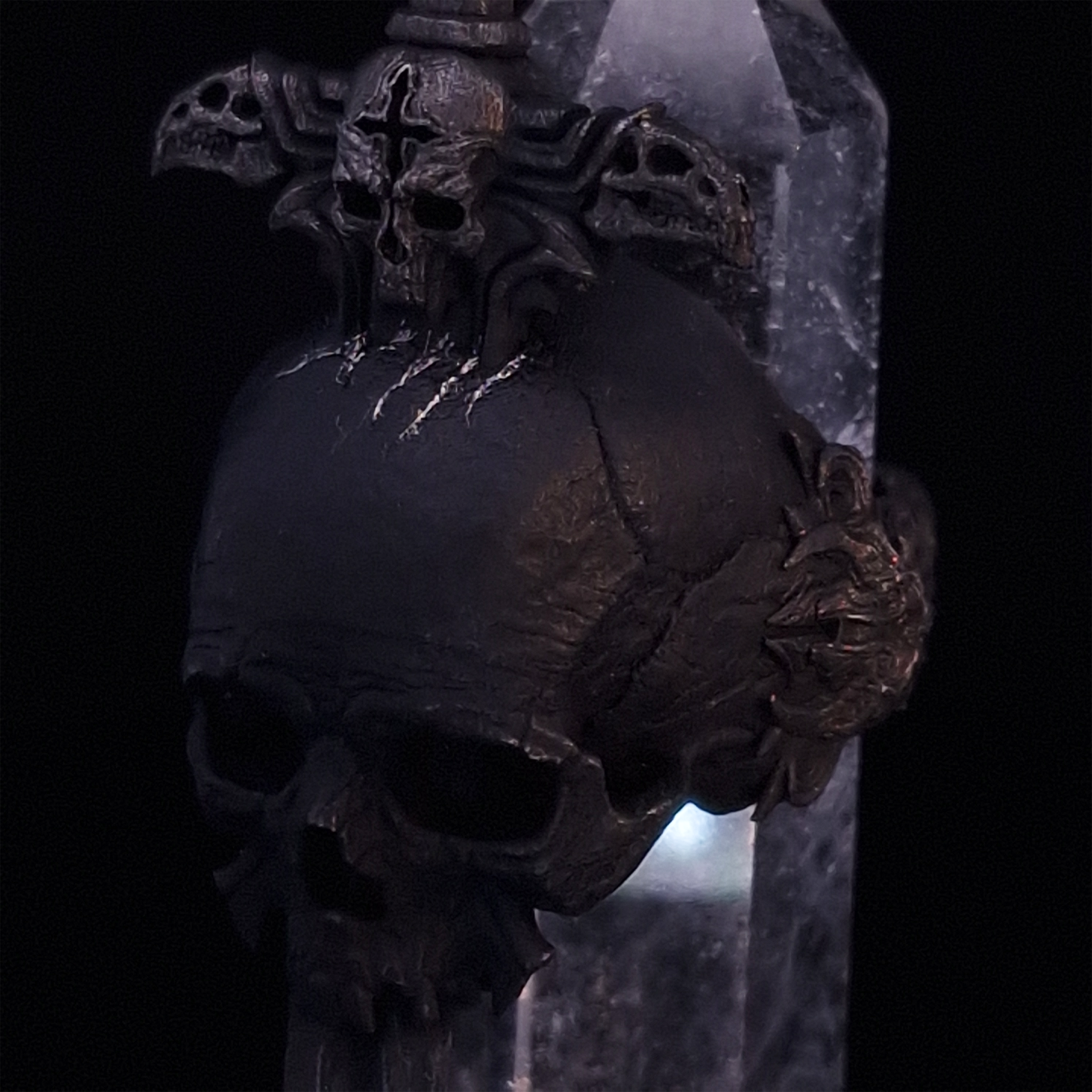 Close-up front-left facing view of the Adversarius Mortis ring in the Revenant 2 finish, supported by a crystal for balance, shown on a turntable with a black background.