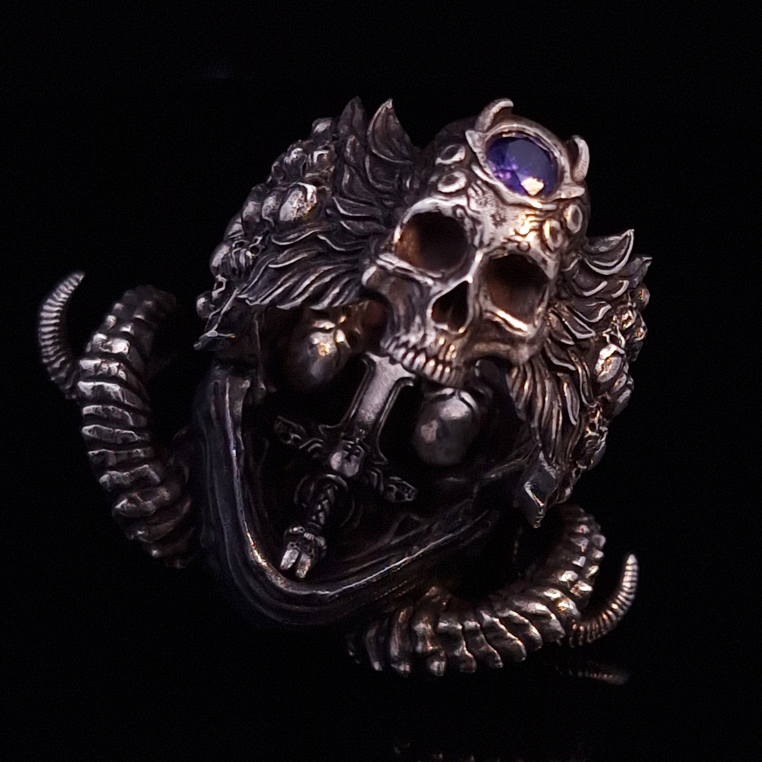 Back view of the Sword of Damocles ring in the Fallen finish, focusing on the gemstone detail, on a turntable with a black background.