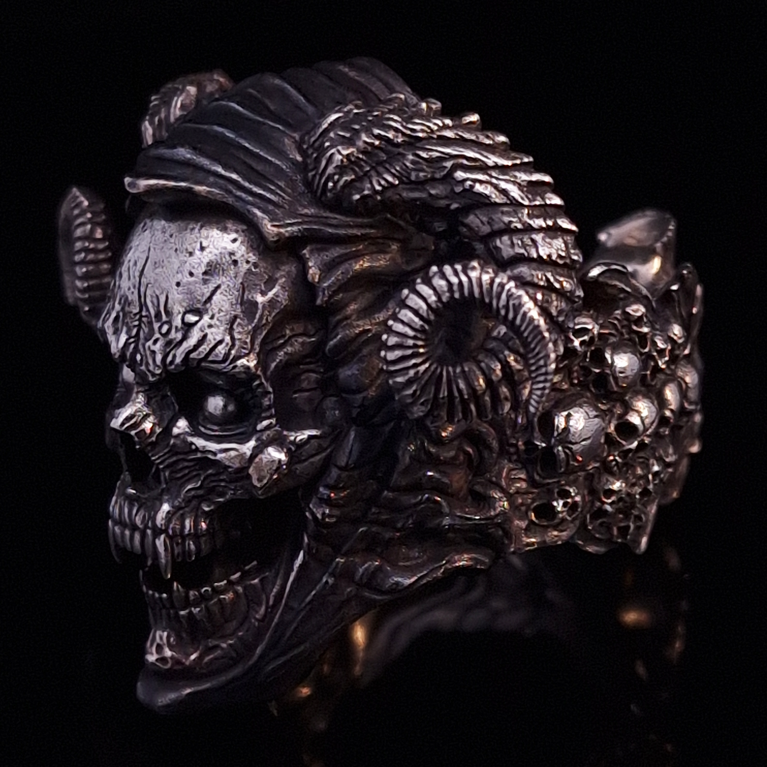 Front-left facing view of the Sword of Damocles ring in the Fallen finish, displayed on a turntable against a black background.