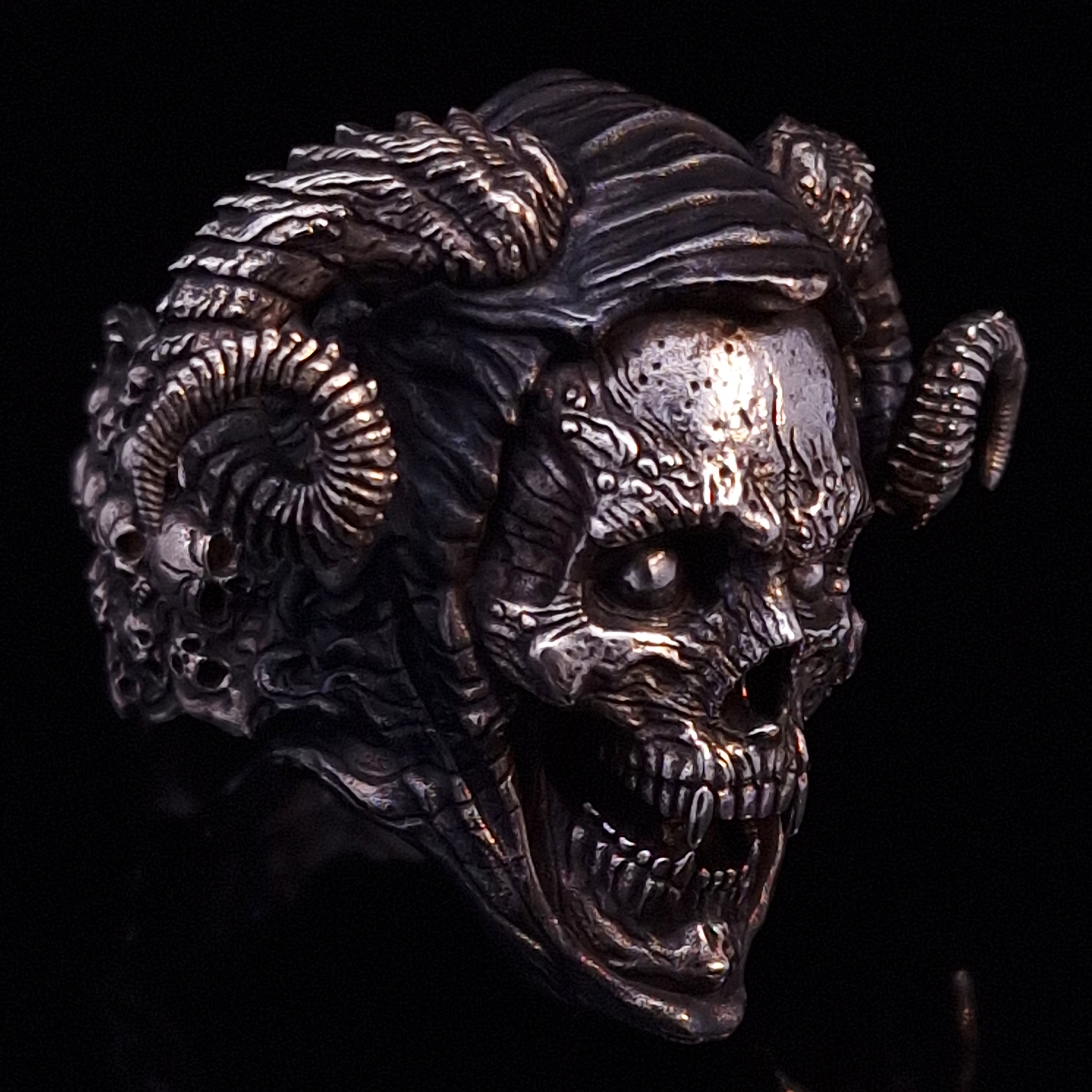 Front-right facing view of the Sword of Damocles ring in the Fallen finish, displayed on a turntable against a black background.