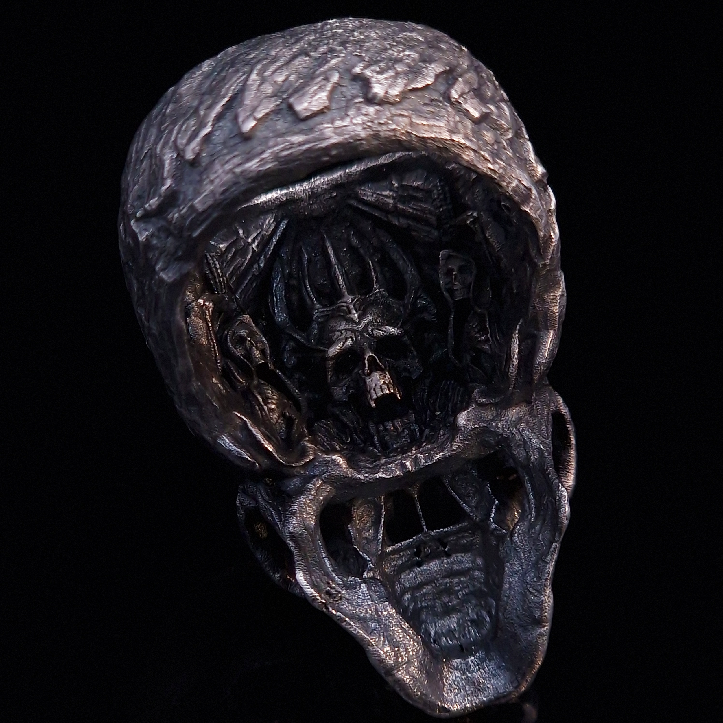 Rear view of the Invidia Mortis ring in the Fallen finish, focusing on the internal and back design, on a turntable with a black background.