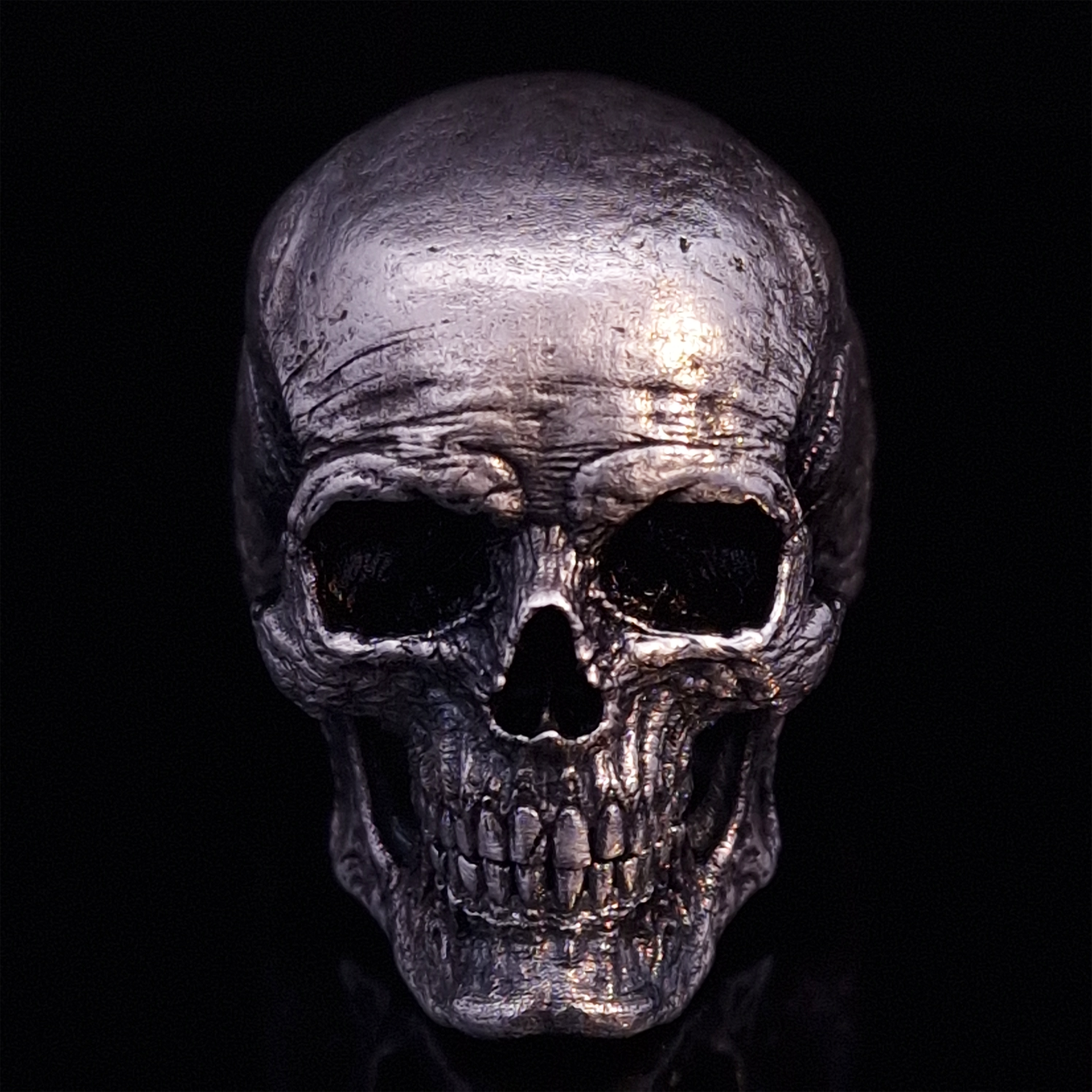 Front-facing view of the Invidia Mortis ring in the Fallen finish, displayed on a turntable against a black background.
