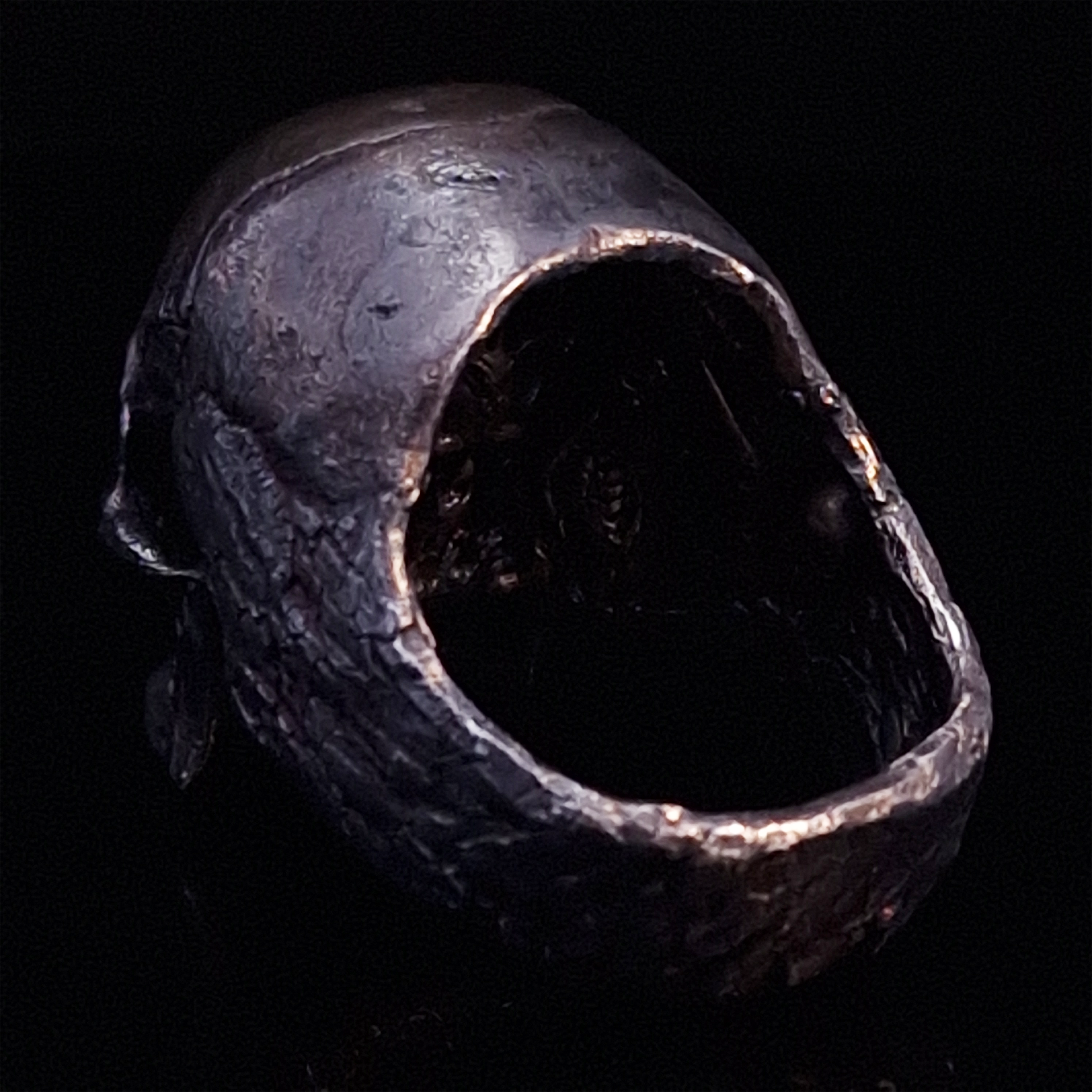Back-left view of the Invidia Mortis ring in the Revenant 1 finish, on a turntable with a black background.
