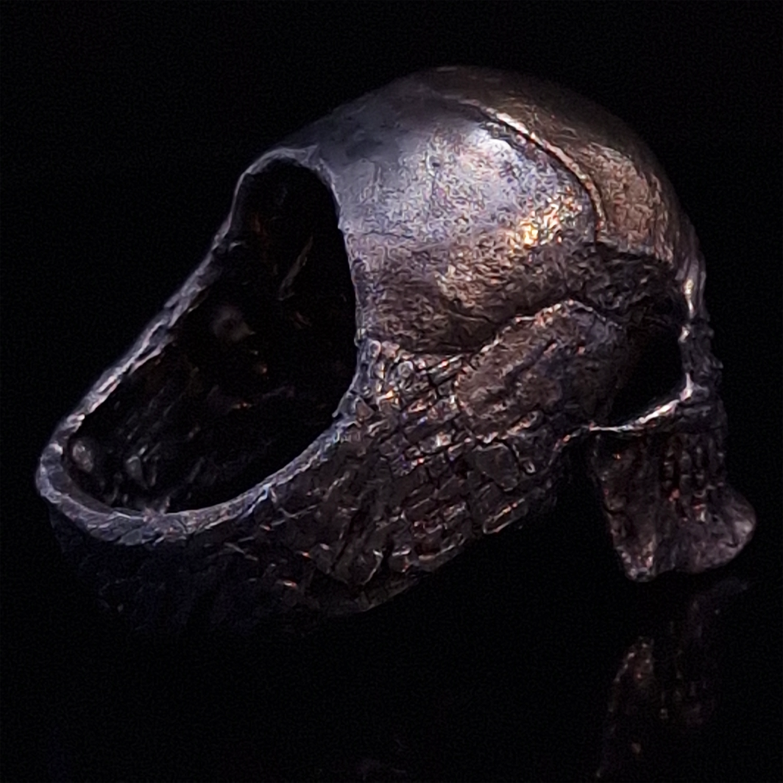 Back-right view of the Invidia Mortis ring in the Revenant 1 finish, on a turntable with a black background.