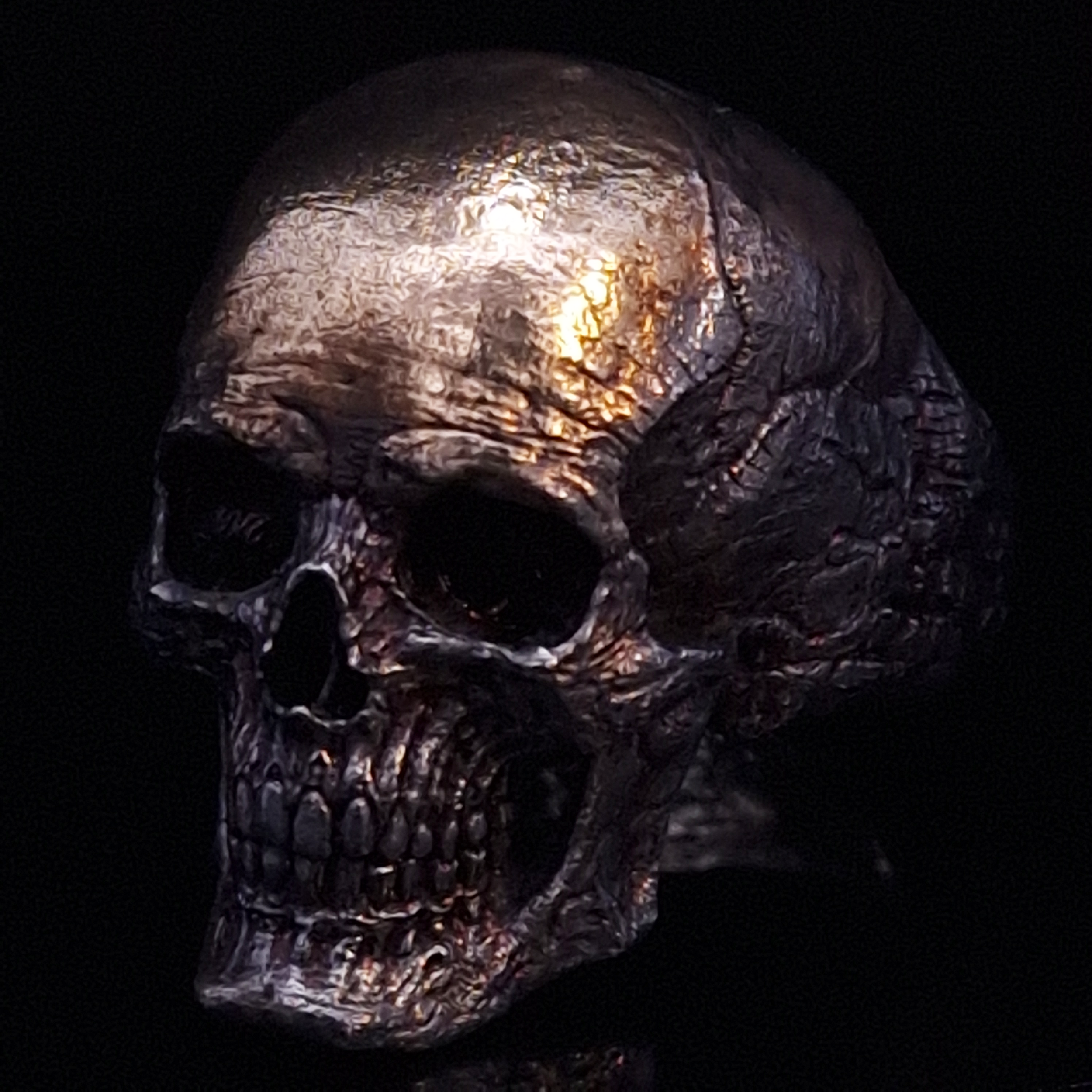 Front-left facing view of the Invidia Mortis ring in the Revenant 1 finish, displayed on a turntable against a black background.