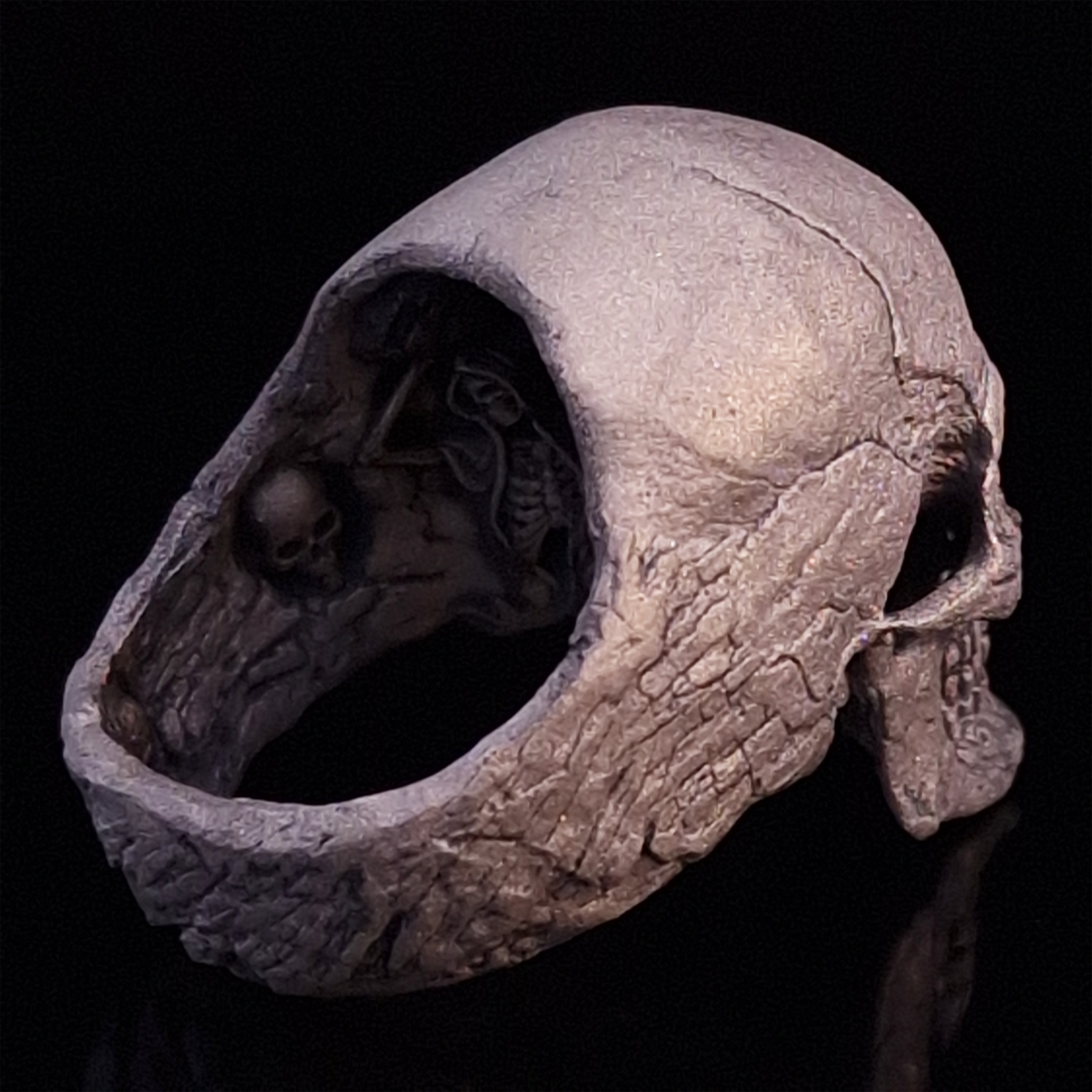 Back-right view of the Invidia Mortis ring in the Wraith finish, on a turntable with a black background.