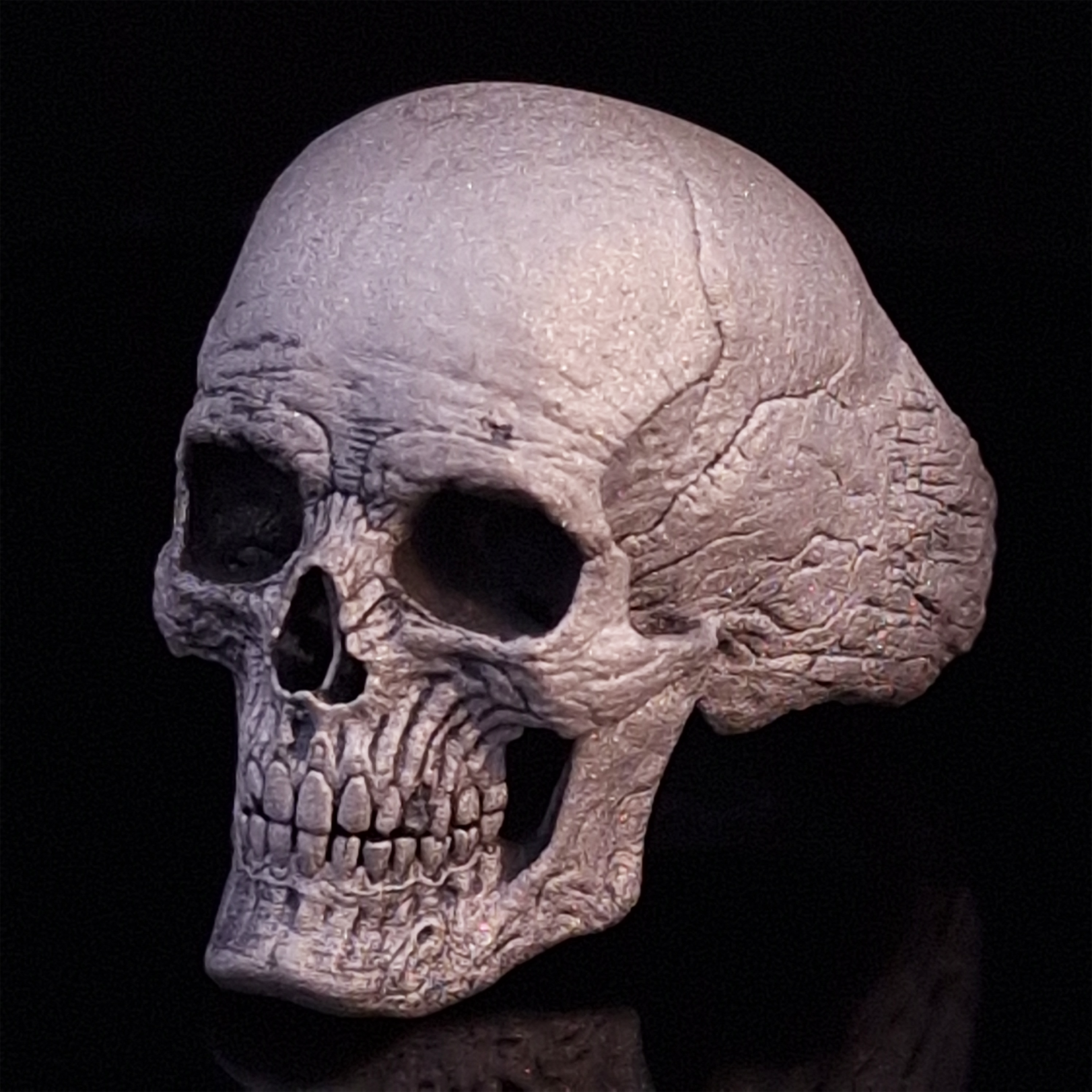 Front left view of the Invidia Mortis ring in the Wraith finish, displayed on a turntable against a black background.