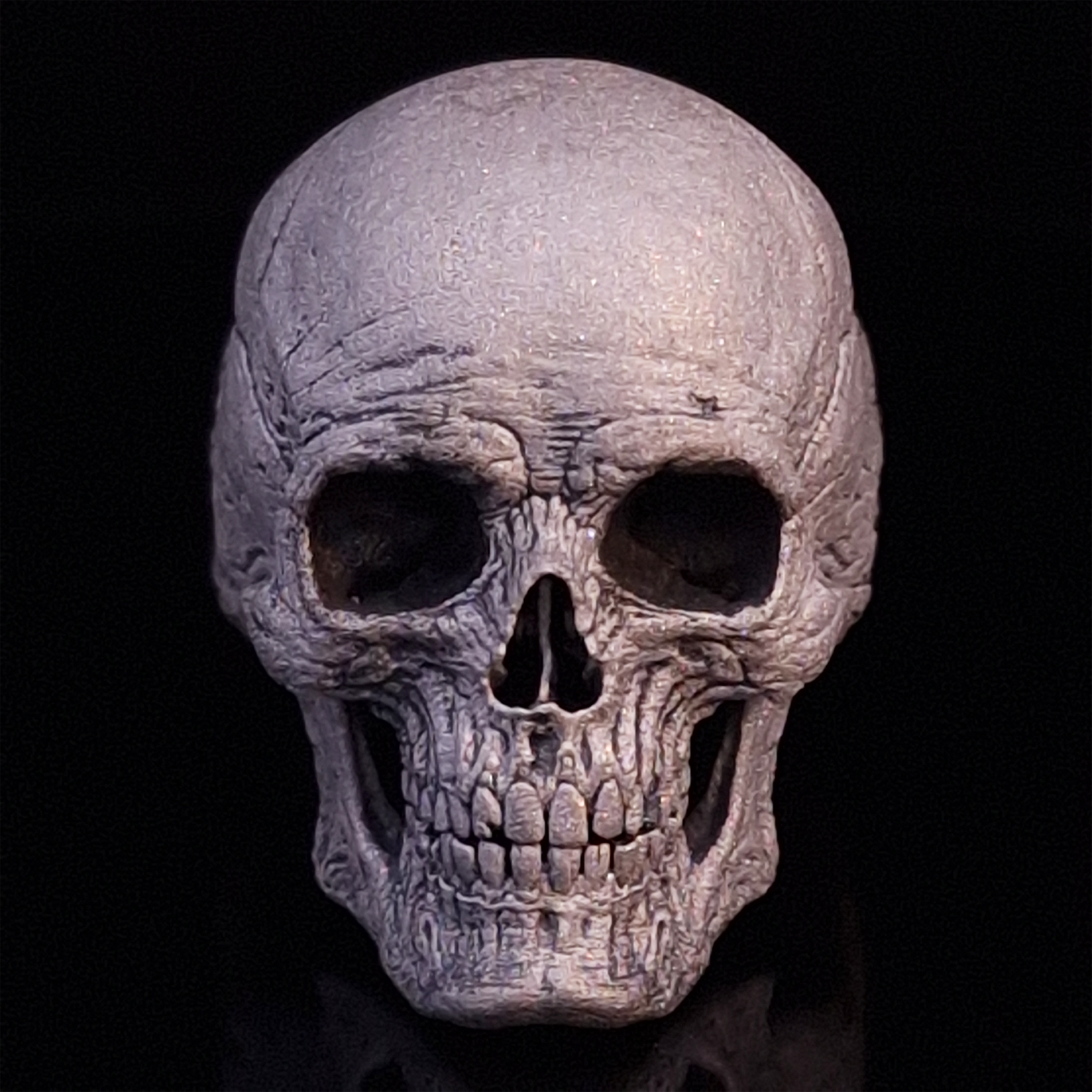 Front-facing view of the Invidia Mortis ring in the Wraith finish, displayed on a turntable against a black background.