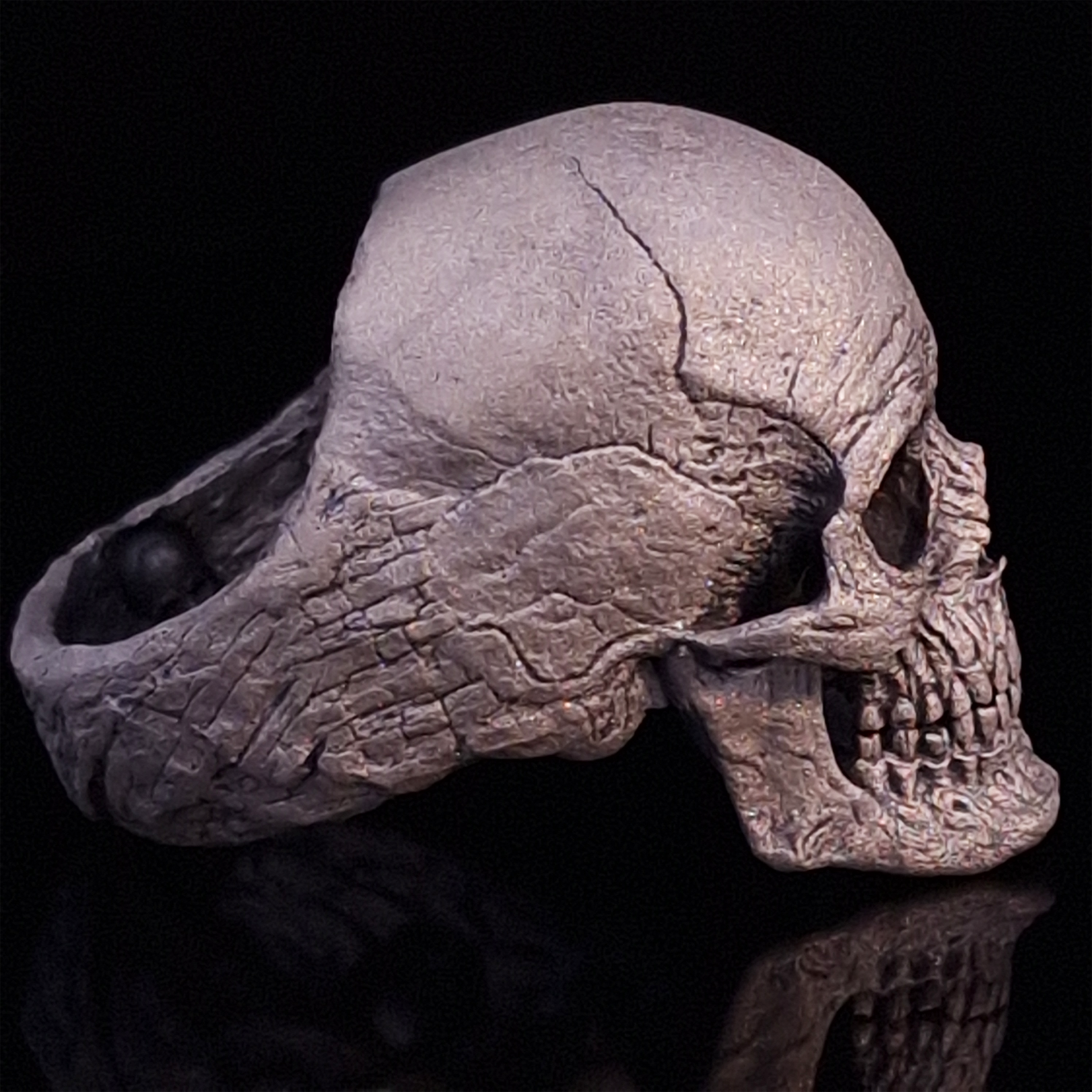 Side-right view highlighting the detailed band of the Invidia Mortis ring in the Wraith finish, shown on a turntable with a black background.