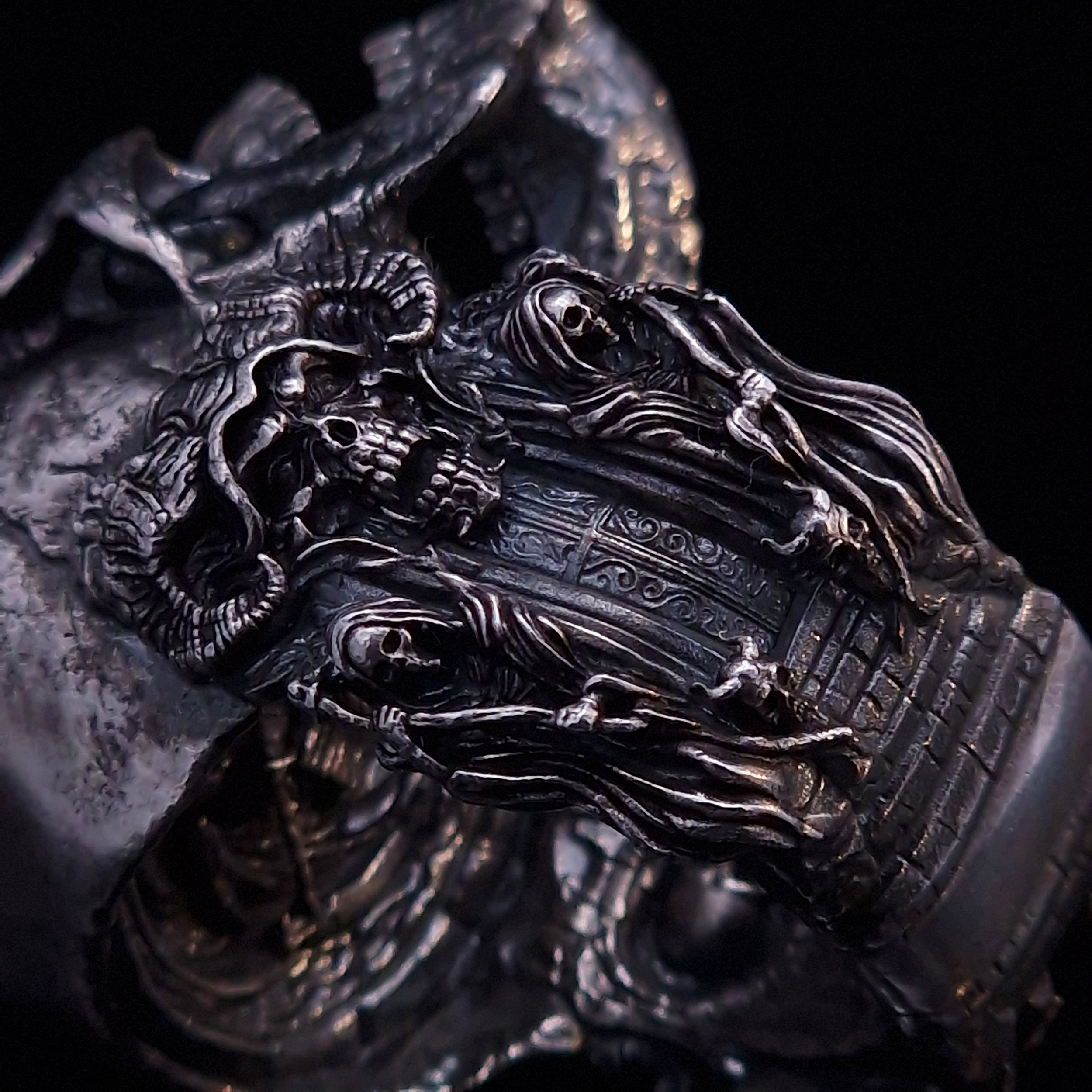 Close-up side view highlighting the detailed band of the Nexus Mortis ring in the Fallen finish, shown on a turntable with a black background.