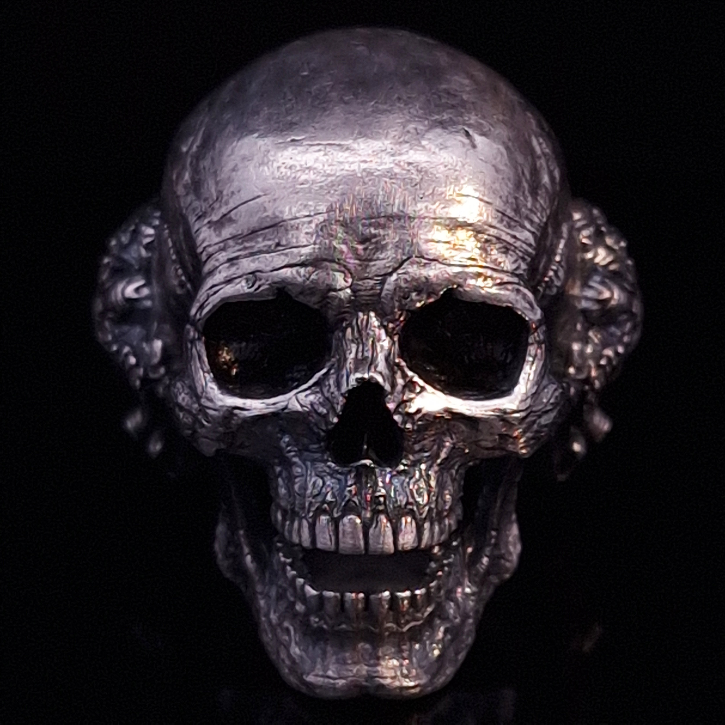 Front-facing view of the Nexus Mortis ring in the Fallen finish, displayed on a turntable against a black background.