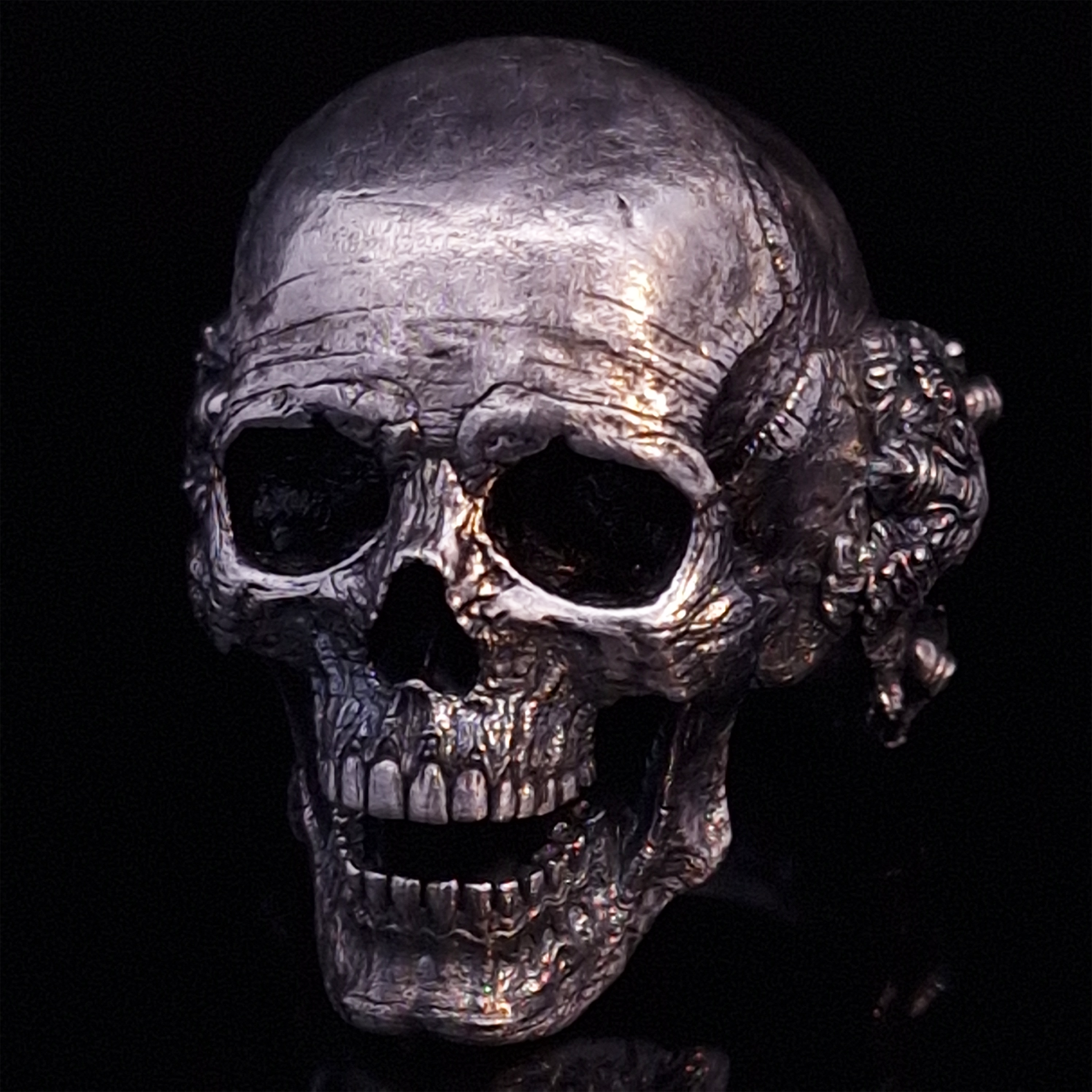 Front-left facing view of the Nexus Mortis ring in the Fallen finish, displayed on a turntable against a black background.