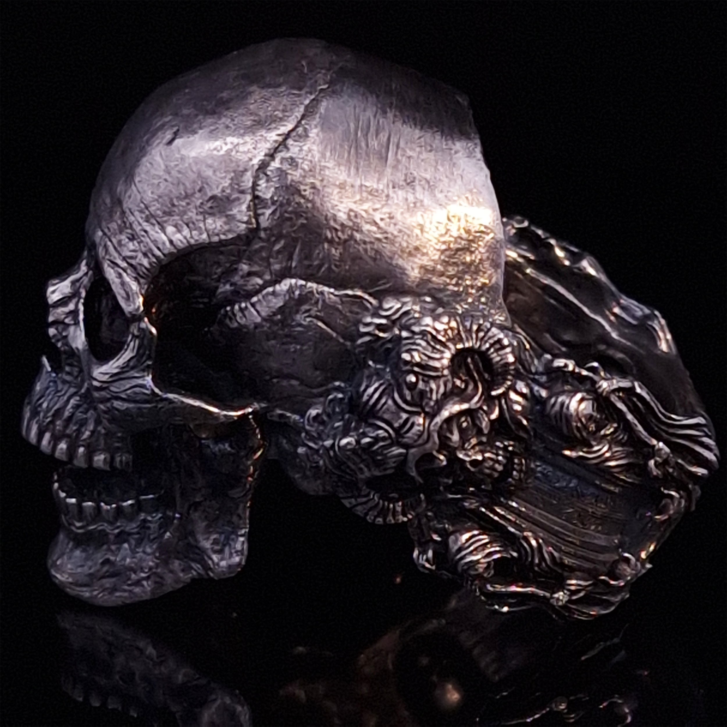 Side-left view highlighting the detailed band of the Nexus Mortis ring in the Fallen finish, shown on a turntable with a black background.