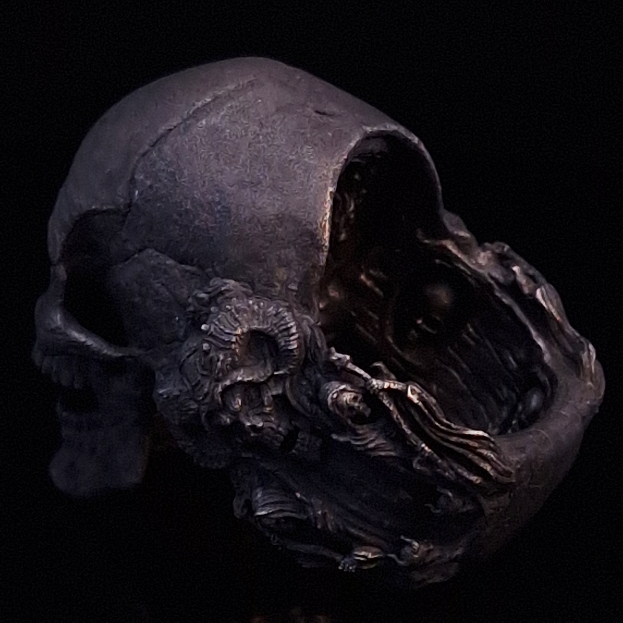 Back-left view of the Nexus Mortis ring in the Revenant 3 finish, focusing on the reaper band, on a turntable with a black background.