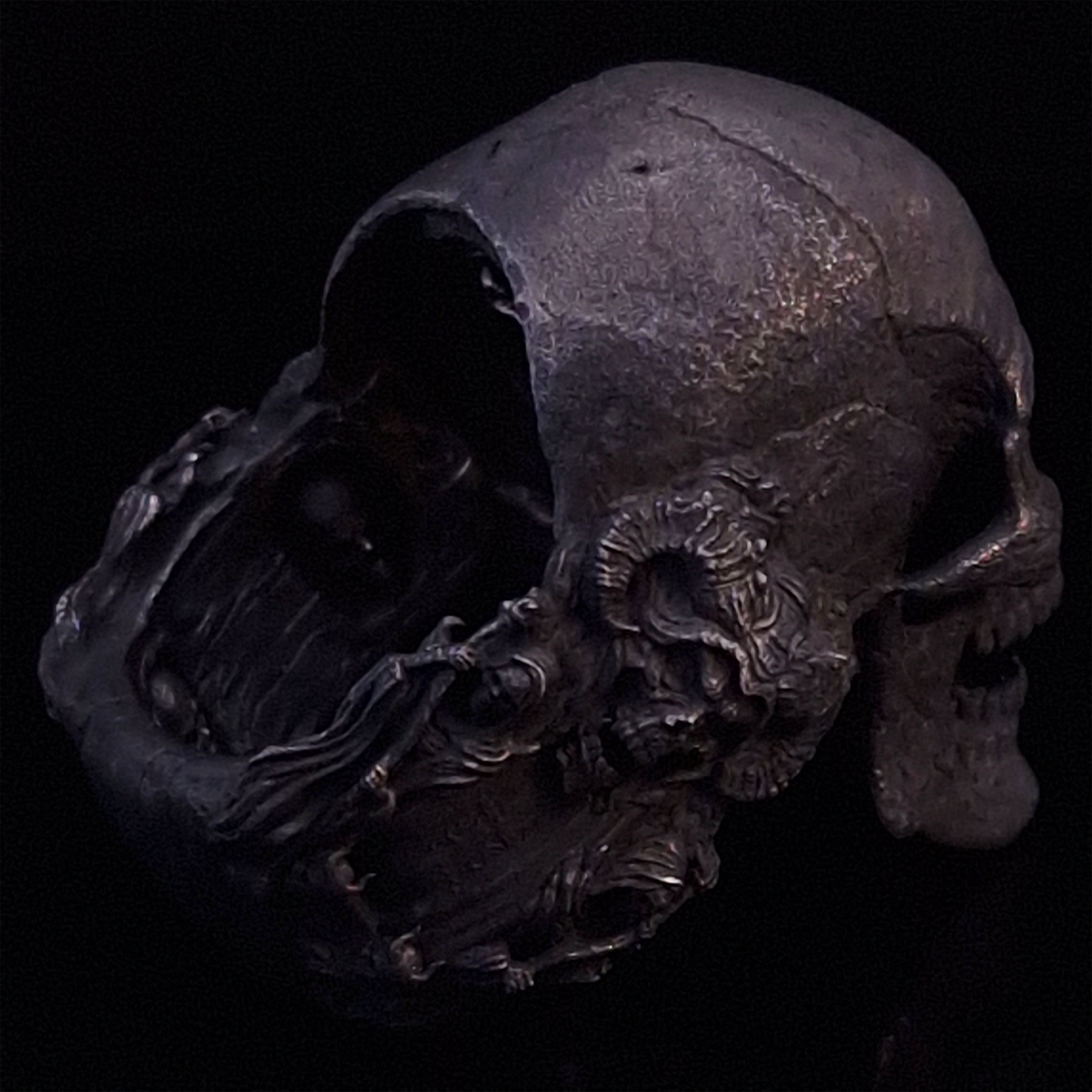 Back-right view of the Nexus Mortis ring in the Revenant 3 finish, focusing on the reaper band, on a turntable with a black background.