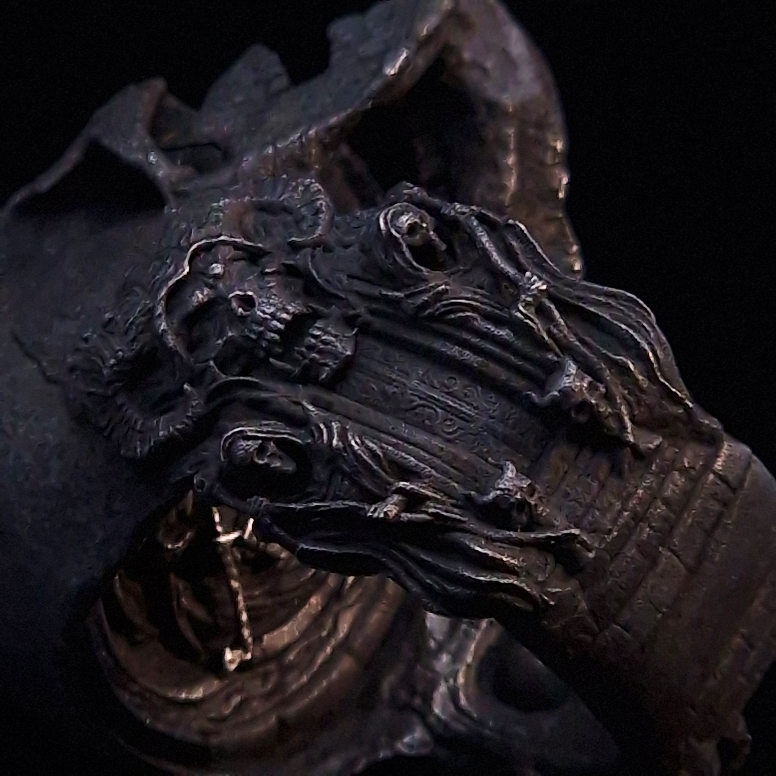 Close-up side view highlighting the detailed band of the Nexus Mortis ring in the Revenant 3 finish, shown on a turntable with a black background.