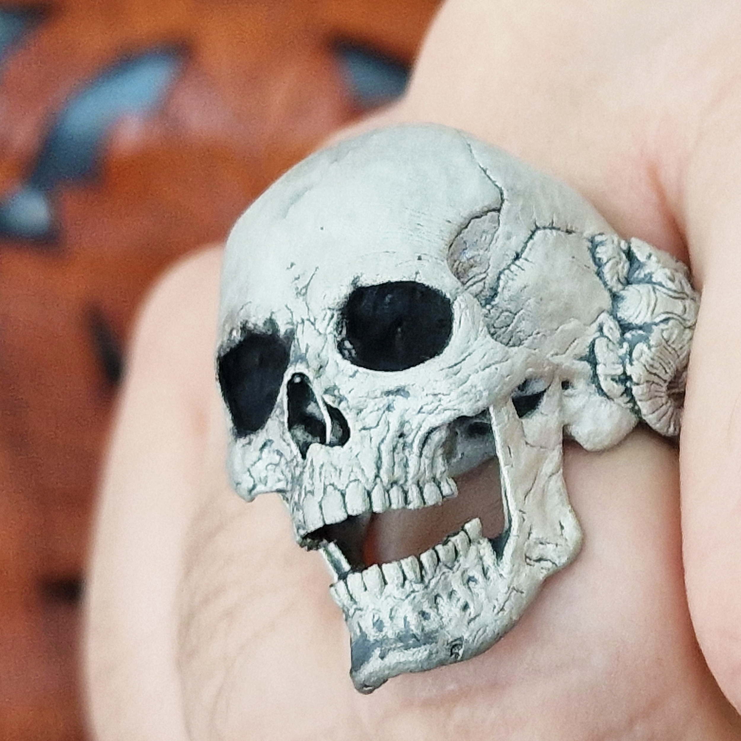 Fist pointed toward the camera in natural light, wearing the Nexus Mortis ring in the Wraith finish, highlighting its details and texture.