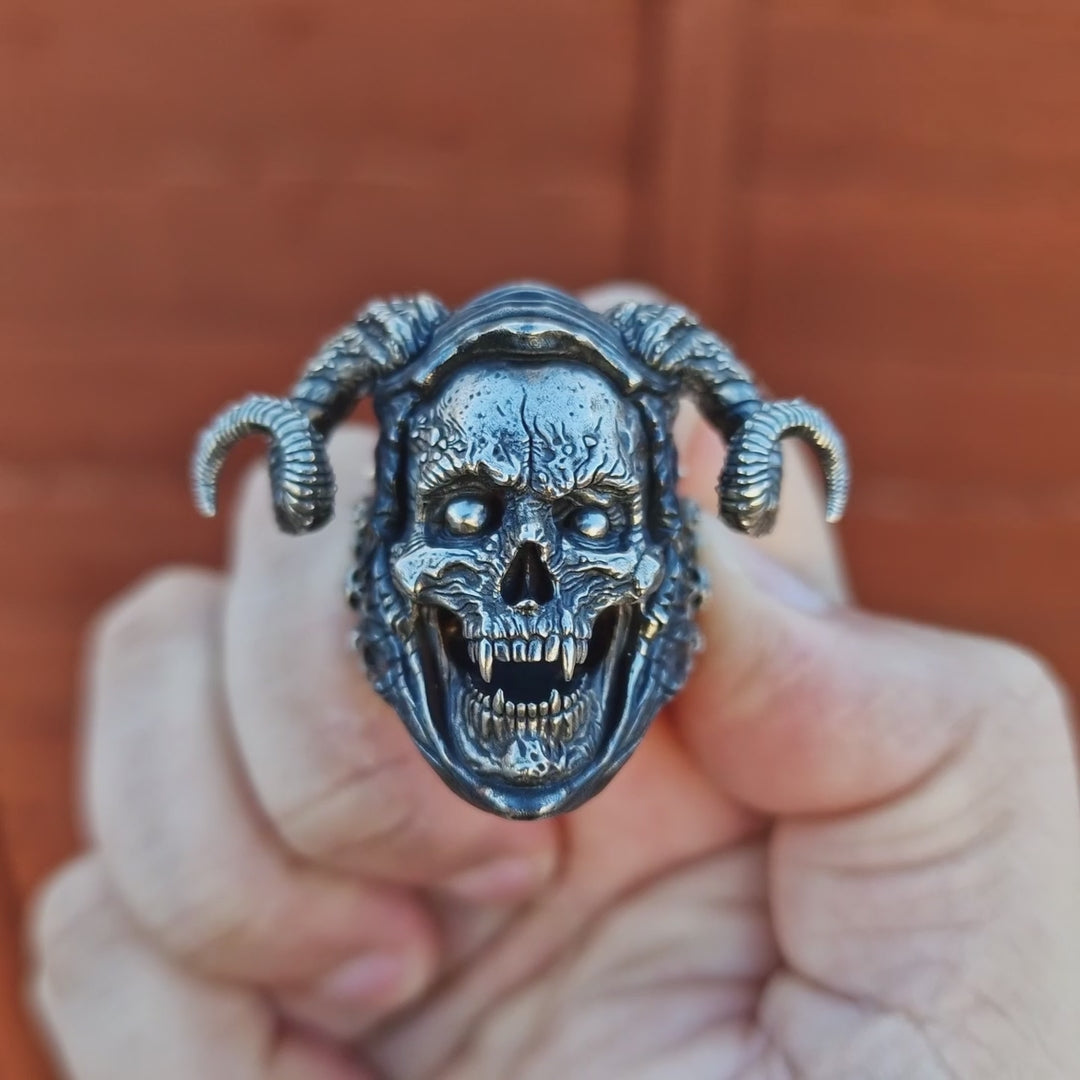 Outdoor close-up of the Sword of Damocles ring in the Fallen finish, with sunlight glinting off the polished metal to highlight the sharp, clean details.