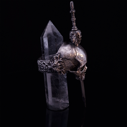 Side-right view of the Adversarius Mortis ring in the Fallen finish, with crystal support visible, highlighting the intricate band design on a turntable.