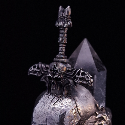 Front-left facing close-up view of the Adversarius Mortis ring in the Fallen finish, focusing on the design of the sword handle.