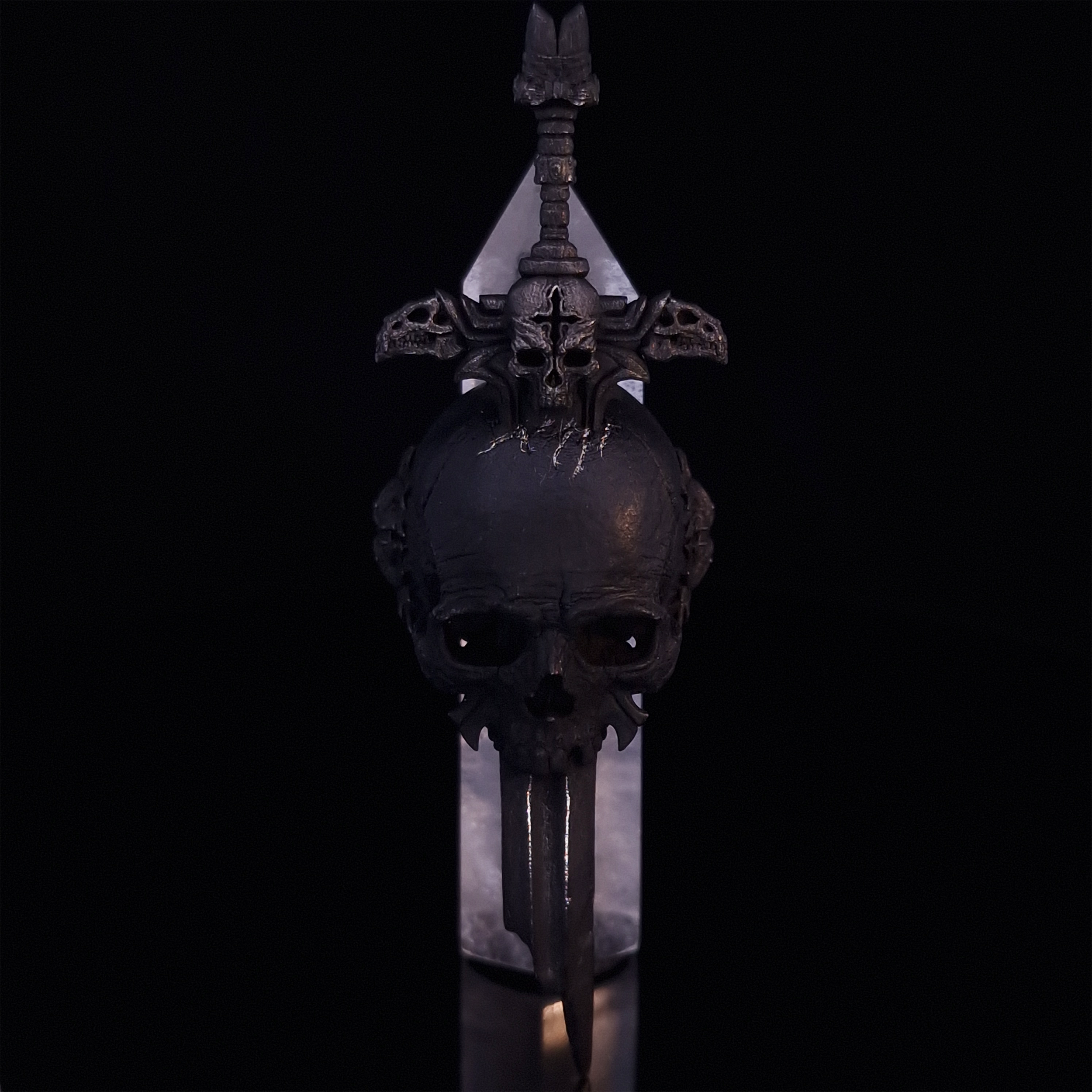 Front-facing view of the Adversarius Mortis ring in the Revenant 2 finish, supported by a crystal for balance, shown on a turntable with a black background.