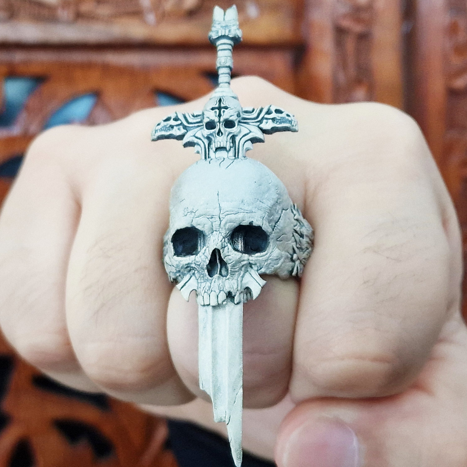 Fist pointed toward the camera in natural light, wearing the Adversarius Mortis ring in the Wraith finish, highlighting its details and texture.