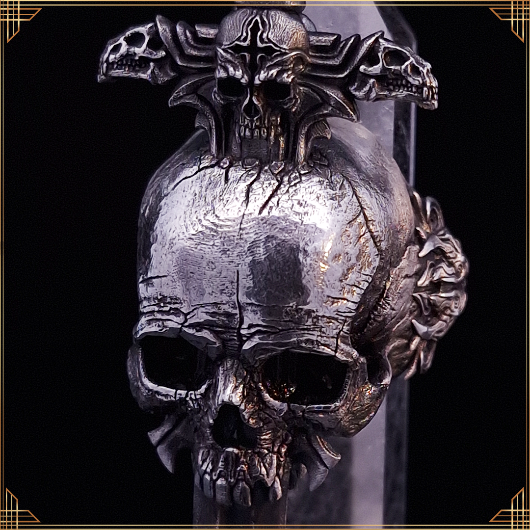 Front view of the Adversarius Mortis ring in the Fallen finish, with a balancing crystal, on black background with gold border.