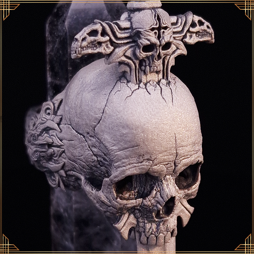 Front diagonal view of the Adversarius Mortis ring in the Wraith finish, with a balancing crystal, on black background with gold border.