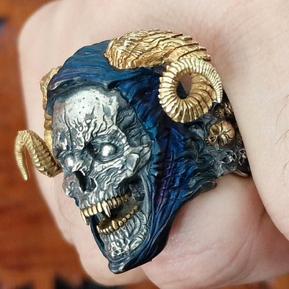 Fist pointed toward the camera in natural light, wearing the Sword of Damocles ring in the Eternal finish, showcasing its gold and blue rhodium accents.