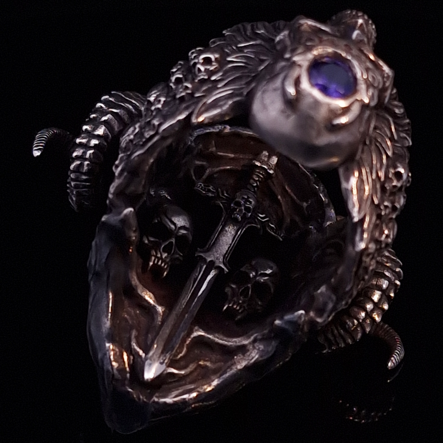 Close-up of the inner sword design of the Sword of Damocles ring in the Fallen finish, captured on a turntable with a black backdrop.