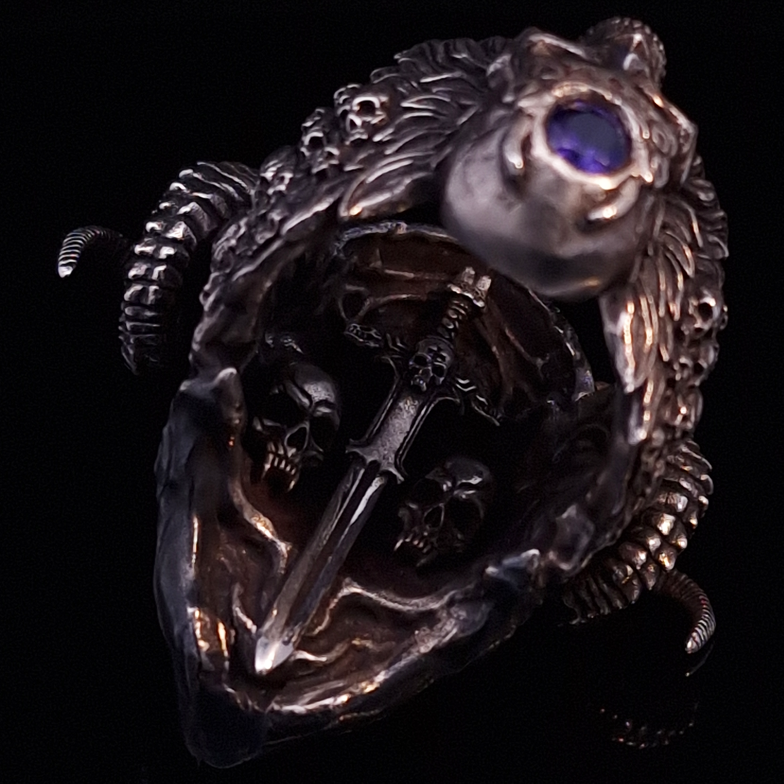Close-up of the inner sword design of the Sword of Damocles ring in the Fallen finish, captured on a turntable with a black backdrop.