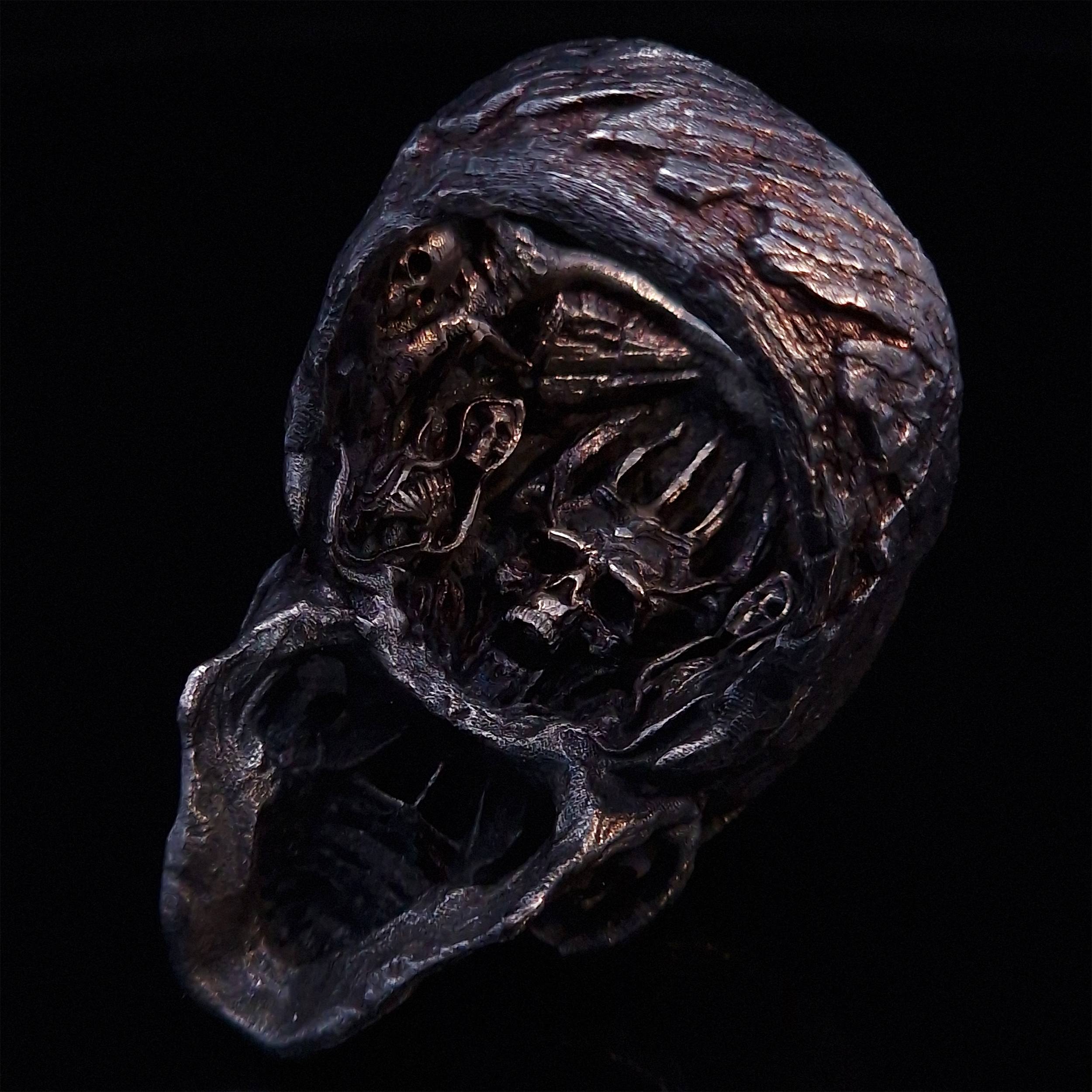 Rear view of the Invidia Mortis ring in the Revenant 1 finish, focusing on the internal and back design, on a turntable with a black background.