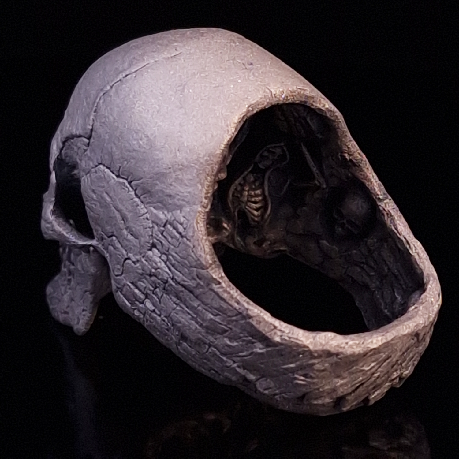 Back-left view of the Invidia Mortis ring in the Wraith finish, on a turntable with a black background.
