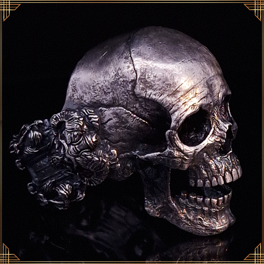 Close-up of the Nexus Mortis ring in the Fallen finish, shown facing the right, against a black background with a gold border.