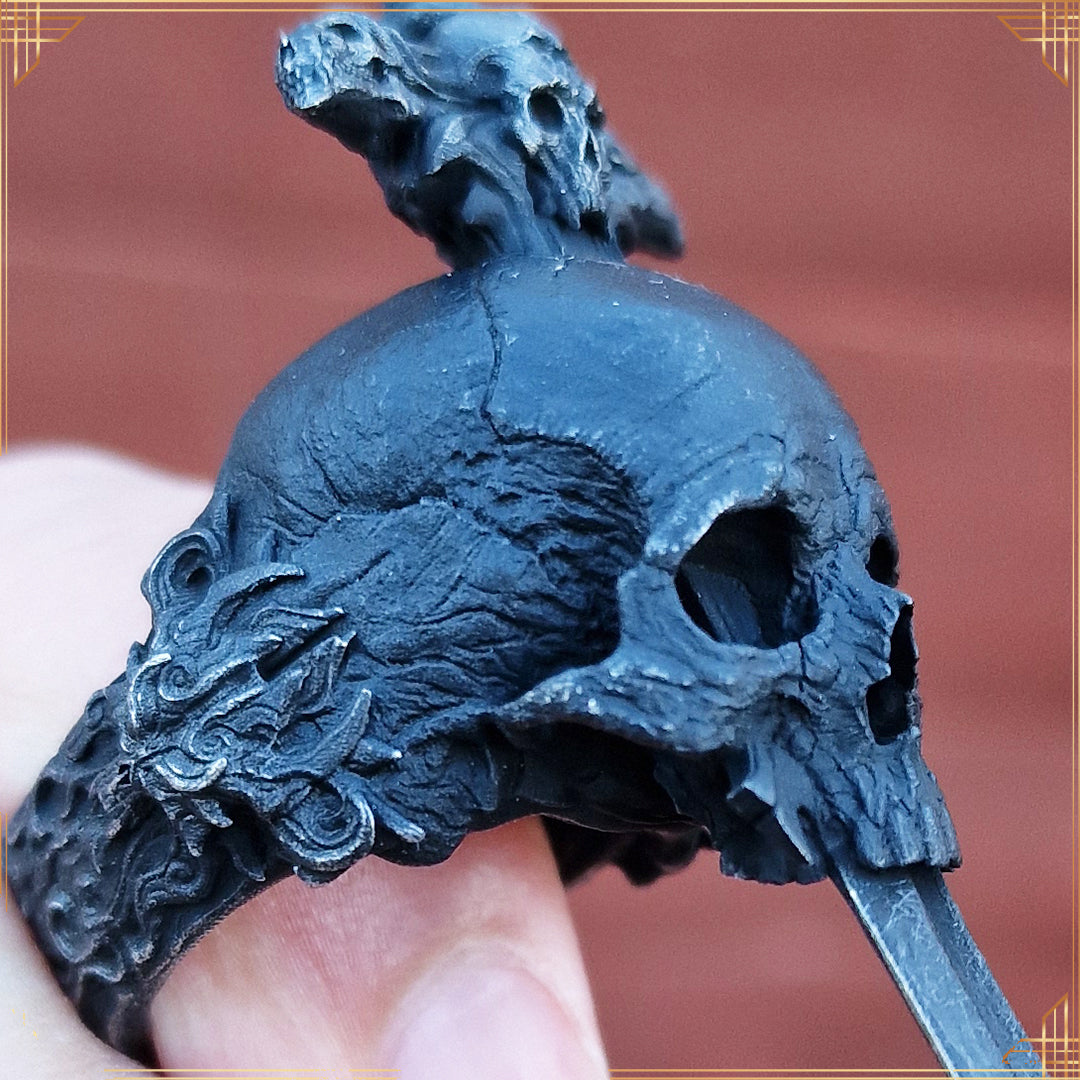 Natural light image of the Adversarius Mortis ring in Revenant 2, held in hand to showcase its bold profile and the sword piercing through the skull design.